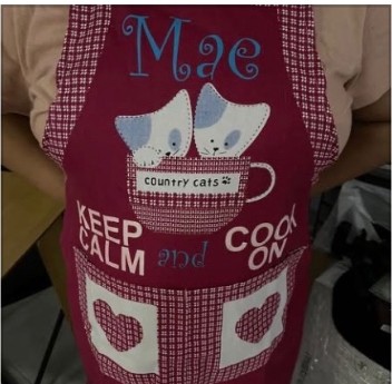 Maroon apron personalized with the name Mae and cat artwork